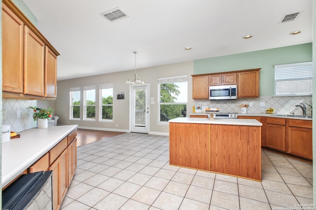 4922 Augusta, San Antonio, TX 78247 - kitchen featuring stainless steel microwave, light tile patterned floors, light countertops, backsplash, and a center island