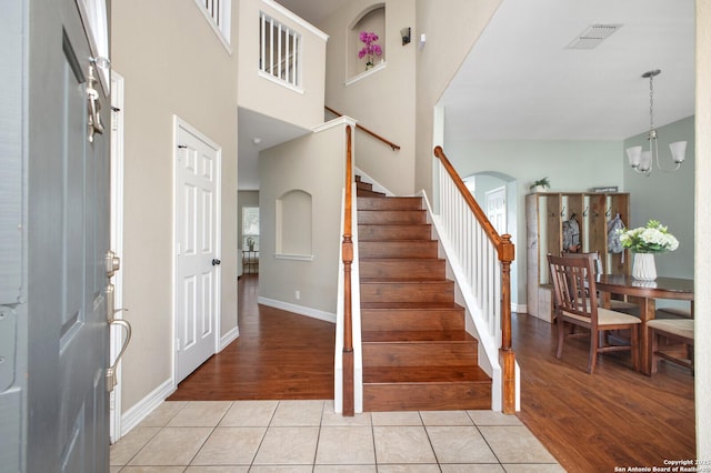 4922 Augusta, San Antonio, TX 78247 - foyer with stairs, a chandelier, light wood finished floors, arched walkways, and a high ceiling