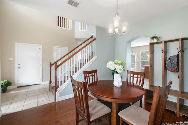 4922 Augusta, San Antonio, TX 78247 - dining space with arched walkways, a chandelier, stairs, and light tile patterned floors