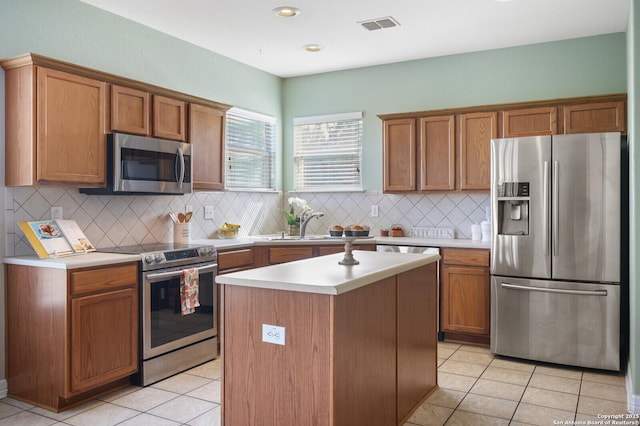 4922 Augusta, San Antonio, TX 78247 - kitchen featuring appliances with stainless steel finishes, light countertops, tasteful backsplash, light tile patterned flooring, and a center island