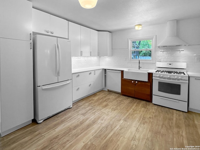 737 N Central, New Braunfels, TX 78130 - kitchen with white appliances, custom exhaust hood, light wood-style flooring, light countertops, and tasteful backsplash