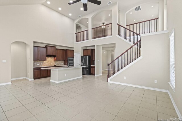 8503 Kallison Arbor, San Antonio, TX 78254 - unfurnished living room featuring a ceiling fan, high vaulted ceiling, light tile patterned floors, stairway, and arched walkways