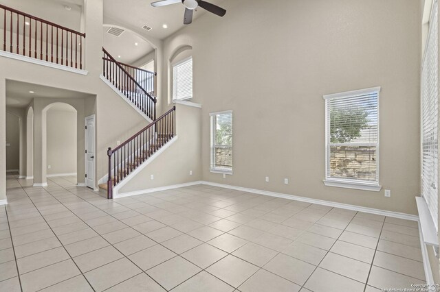 8503 Kallison Arbor, San Antonio, TX 78254 - unfurnished living room with a high ceiling, ceiling fan, plenty of natural light, light tile patterned floors, and stairway