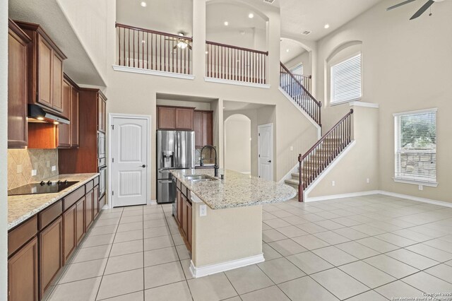8503 Kallison Arbor, San Antonio, TX 78254 - kitchen featuring black electric stovetop, stainless steel fridge, a towering ceiling, under cabinet range hood, and light tile patterned floors