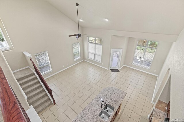 8503 Kallison Arbor, San Antonio, TX 78254 - unfurnished living room with light tile patterned floors, high vaulted ceiling, stairs, and a ceiling fan