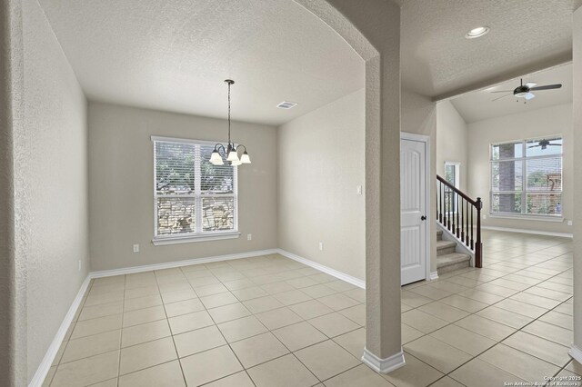 8503 Kallison Arbor, San Antonio, TX 78254 - empty room featuring a textured ceiling, light tile patterned floors, arched walkways, stairway, and ceiling fan