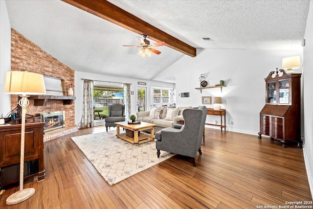 3527 Oakhorne St, San Antonio, TX 78247 - living area with ceiling fan, a textured ceiling, a brick fireplace, and wood finished floors