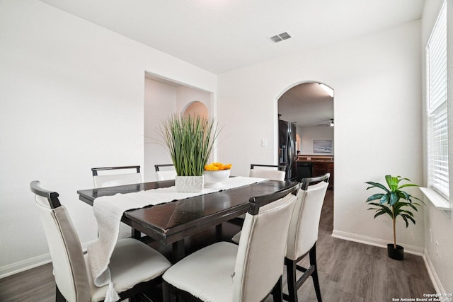 6123 Foster Ml, San Antonio, TX 78222 - dining area with arched walkways, dark wood-style floors, and healthy amount of natural light