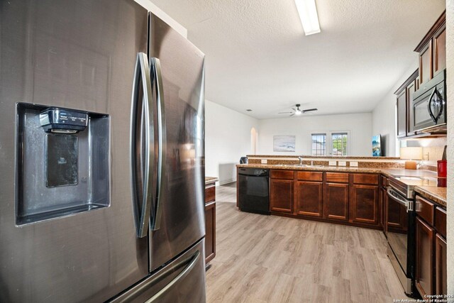 6123 Foster Ml, San Antonio, TX 78222 - kitchen featuring black appliances, a peninsula, light wood-style floors, a ceiling fan, and light stone countertops