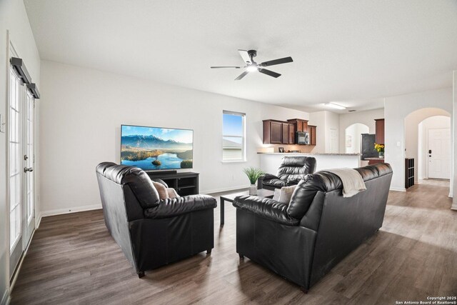 6123 Foster Ml, San Antonio, TX 78222 - living room featuring arched walkways, ceiling fan, and dark wood-style flooring