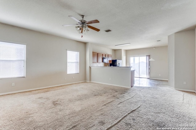4310 Loring, Converse, TX 78109 - unfurnished living room featuring light carpet, a ceiling fan, and a textured ceiling