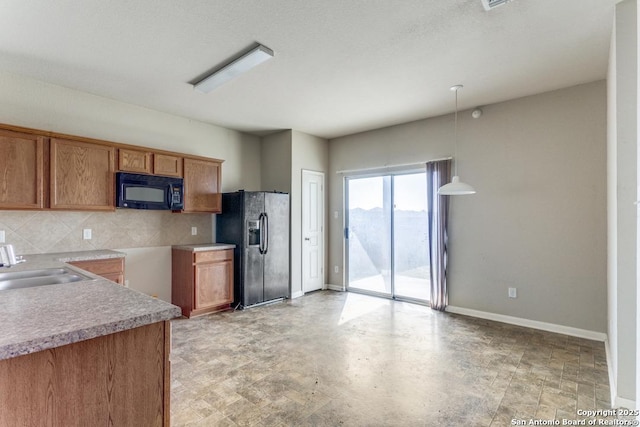 4310 Loring, Converse, TX 78109 - kitchen with black appliances, brown cabinets, tasteful backsplash, light countertops, and hanging light fixtures