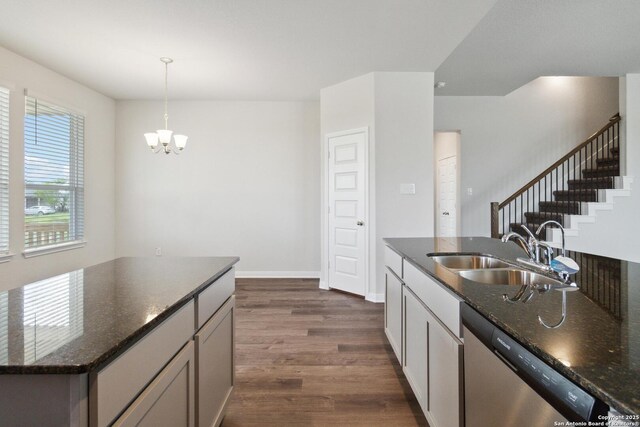 1619 Vista View Dr, Pleasanton, TX 78064 - kitchen with stainless steel dishwasher, dark wood-type flooring, a chandelier, dark stone counters, and decorative light fixtures