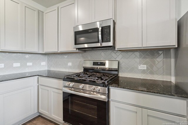 1619 Vista View Dr, Pleasanton, TX 78064 - kitchen featuring stainless steel appliances, dark stone countertops, decorative backsplash, and white cabinets