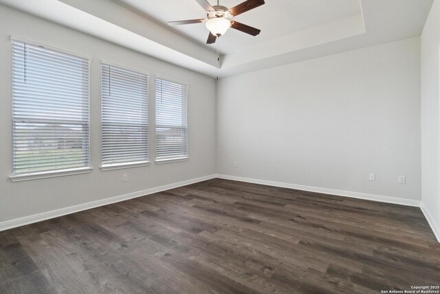 1619 Vista View Dr, Pleasanton, TX 78064 - empty room featuring ceiling fan, healthy amount of natural light, a raised ceiling, and dark wood-style flooring
