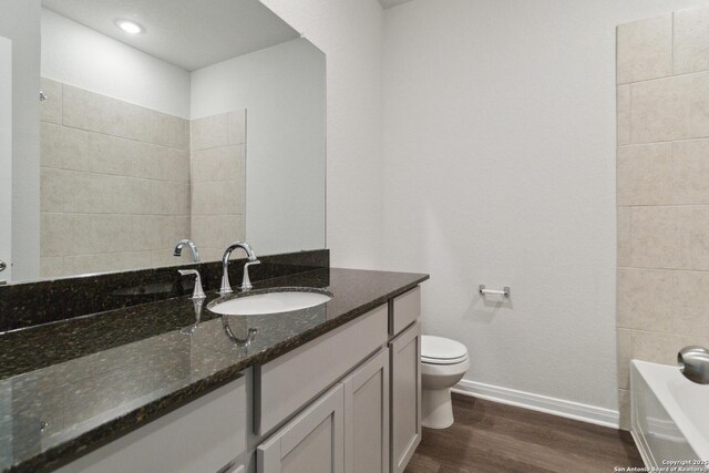 1619 Vista View Dr, Pleasanton, TX 78064 - bathroom with vanity, wood finished floors, and a bathtub