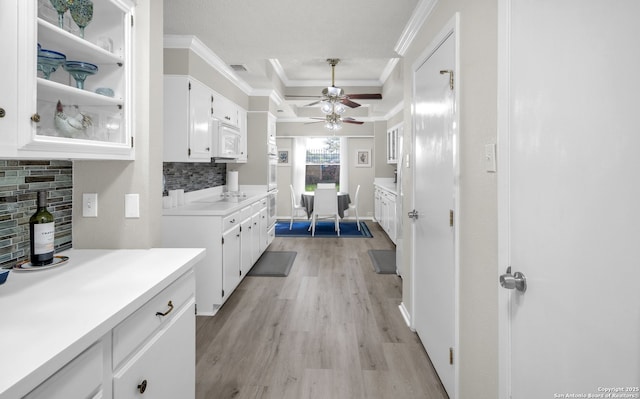 1819 Babcock Unit 605, San Antonio, TX 78229 - kitchen featuring ornamental molding, backsplash, ceiling fan, light wood-type flooring, and white microwave