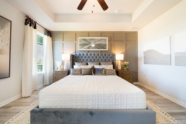1562 Vista View Dr, Pleasanton, TX 78064 - bedroom with light wood-style flooring, a raised ceiling, and a ceiling fan