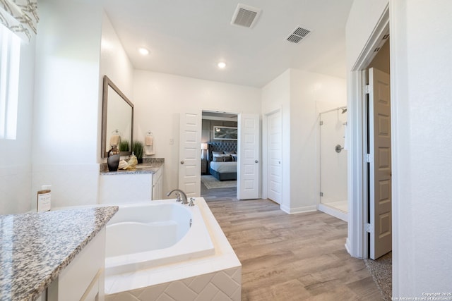 1562 Vista View Dr, Pleasanton, TX 78064 - ensuite bathroom featuring a stall shower, wood finished floors, a bath, vanity, and recessed lighting