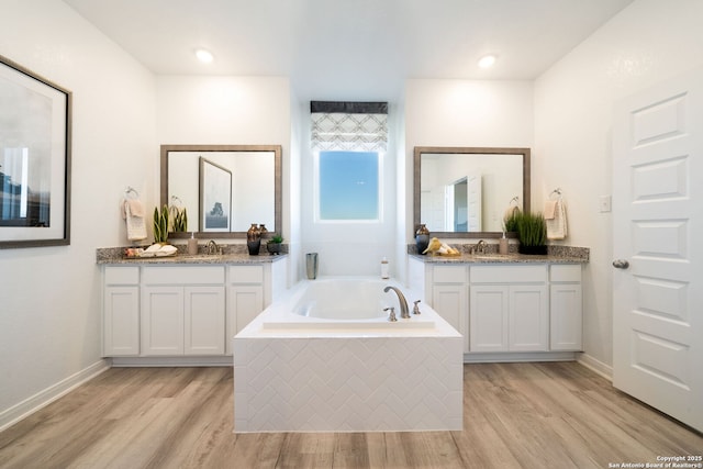 1562 Vista View Dr, Pleasanton, TX 78064 - full bath featuring two vanities, a garden tub, and wood finished floors