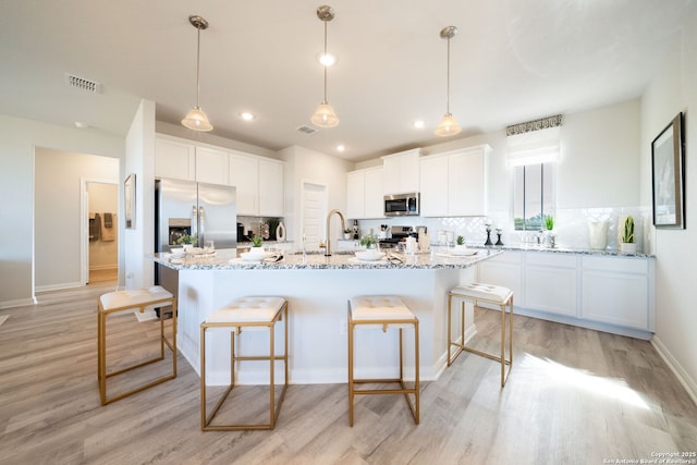1562 Vista View Dr, Pleasanton, TX 78064 - kitchen with appliances with stainless steel finishes, light wood-style floors, backsplash, white cabinets, and recessed lighting