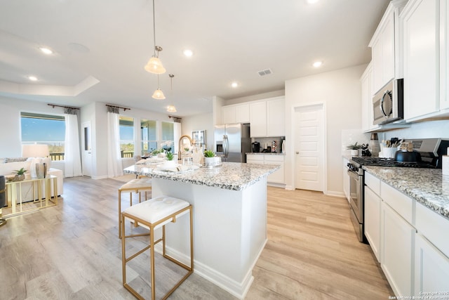 1562 Vista View Dr, Pleasanton, TX 78064 - kitchen with appliances with stainless steel finishes, a kitchen bar, white cabinetry, recessed lighting, and light stone countertops