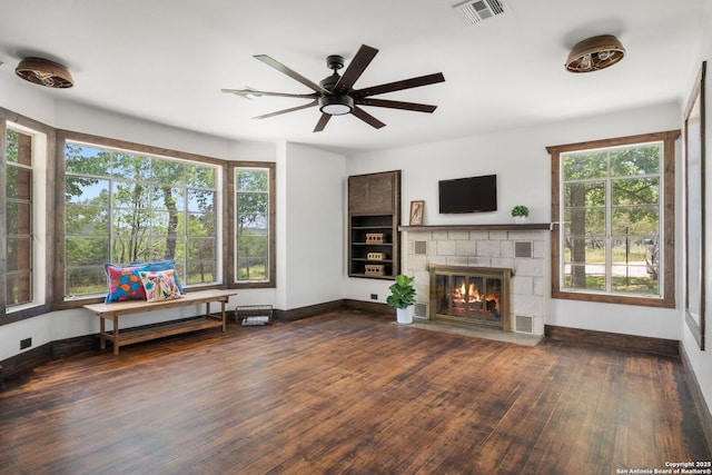 13132 State Highway 16, Medina, TX 78055 - living area with dark wood-style floors, a ceiling fan, plenty of natural light, and a fireplace with flush hearth