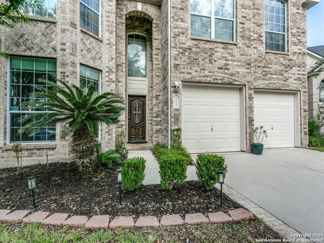 2115 Encino Breeze, San Antonio, TX 78259 - view of front of house with a garage, concrete driveway, and brick siding