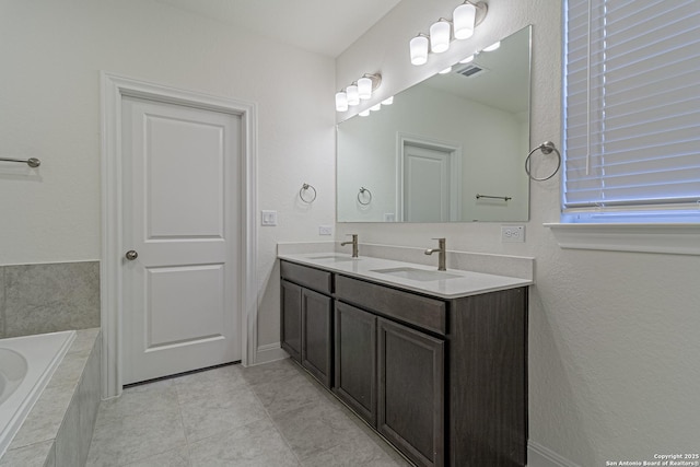 12455 Diagon Aly, San Antonio, TX 78254 - full bath with double vanity, a relaxing tiled tub, and tile patterned flooring