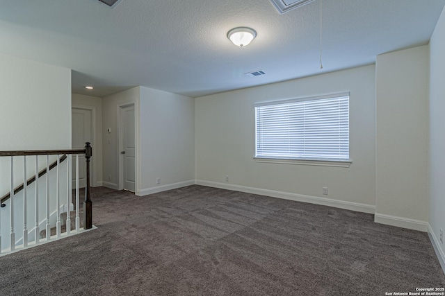 12455 Diagon Aly, San Antonio, TX 78254 - unfurnished room with attic access, dark carpet, and a textured ceiling