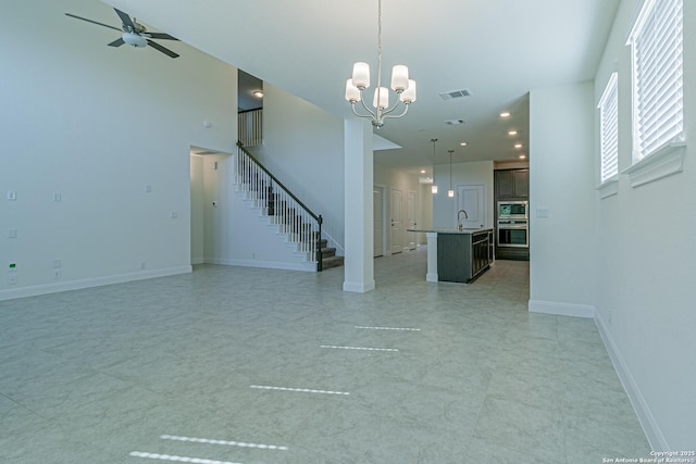 12455 Diagon Aly, San Antonio, TX 78254 - unfurnished living room featuring stairway, a ceiling fan, and a chandelier