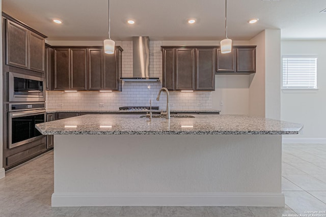 12455 Diagon Aly, San Antonio, TX 78254 - kitchen with stainless steel appliances, wall chimney range hood, dark brown cabinets, light stone countertops, and recessed lighting