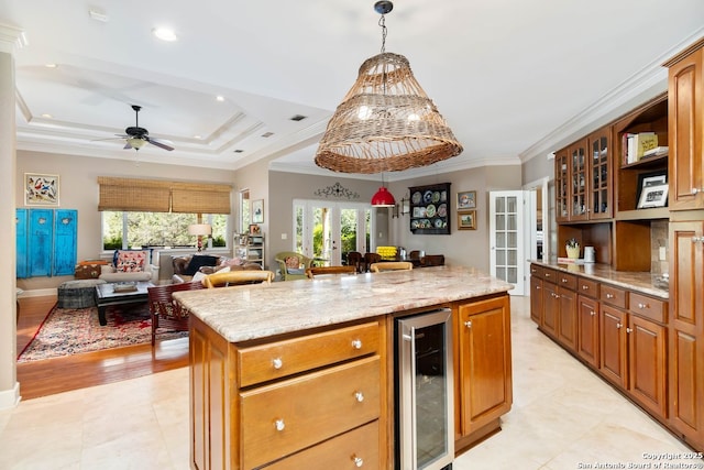 5 Remington, San Antonio, TX 78258 - kitchen with beverage cooler, a center island, open floor plan, decorative light fixtures, and light stone countertops