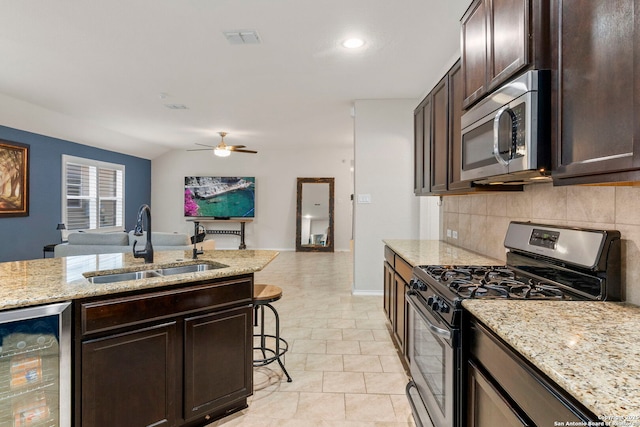 15102 Field Sparrow, San Antonio, TX 78253 - kitchen with appliances with stainless steel finishes, beverage cooler, open floor plan, dark brown cabinets, and tasteful backsplash