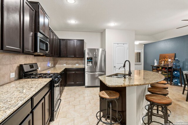 15102 Field Sparrow, San Antonio, TX 78253 - kitchen featuring stainless steel appliances, a kitchen breakfast bar, dark brown cabinetry, light stone counters, and tasteful backsplash