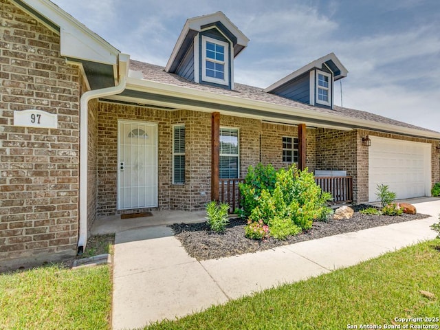 97 Windcrest, Floresville, TX 78114 - view of front facade featuring covered porch, an attached garage, and brick siding