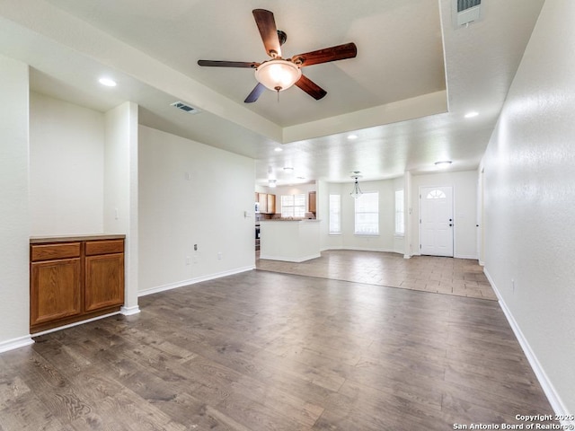 97 Windcrest, Floresville, TX 78114 - unfurnished living room featuring a ceiling fan, recessed lighting, wood finished floors, and a raised ceiling