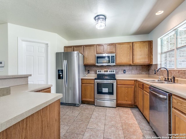 97 Windcrest, Floresville, TX 78114 - kitchen featuring appliances with stainless steel finishes, light countertops, decorative backsplash, and brown cabinets