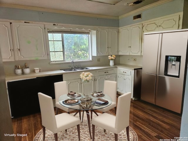 2310 W Gramercy, San Antonio, TX 78201 - kitchen with stainless steel fridge, ornamental molding, light countertops, dark wood finished floors, and white cabinetry