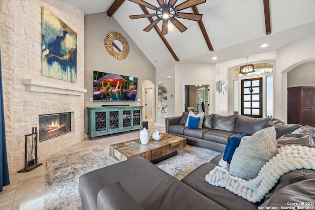 26815 Duet Dr, San Antonio, TX 78260 - living room featuring arched walkways, high vaulted ceiling, beamed ceiling, a ceiling fan, and a fireplace