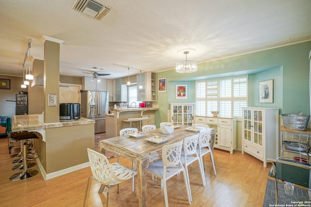 9518 Wahada, San Antonio, TX 78217 - dining room featuring light wood finished floors, a chandelier, a textured ceiling, and ceiling fan