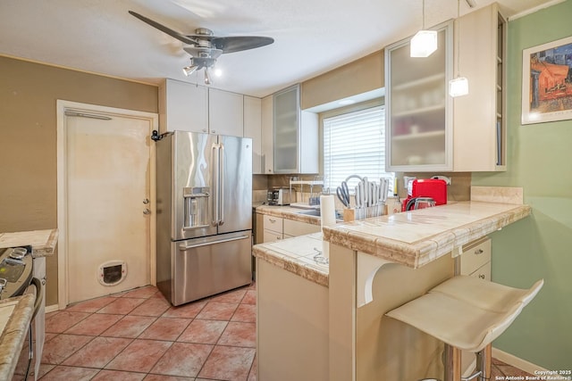 9518 Wahada, San Antonio, TX 78217 - kitchen featuring stainless steel appliances, a peninsula, a ceiling fan, a breakfast bar, and glass insert cabinets