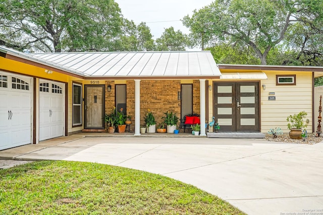 9518 Wahada, San Antonio, TX 78217 - view of front of house with a standing seam roof, concrete driveway, a metal roof, and a garage