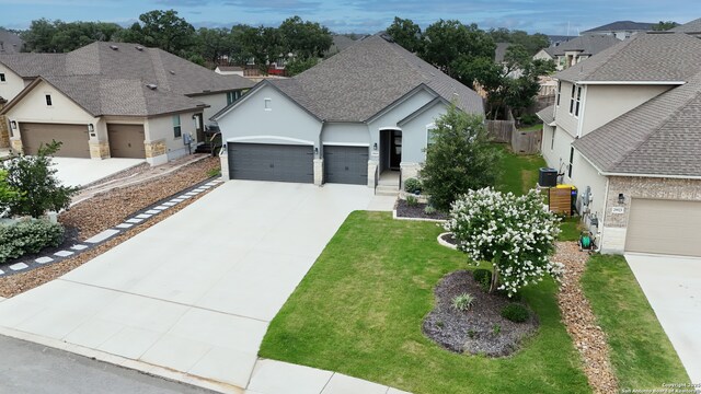 29519 Elkhorn, Fair Oaks Ranch, TX 78015 - view of front of home with a residential view, a garage, stucco siding, a front lawn, and driveway