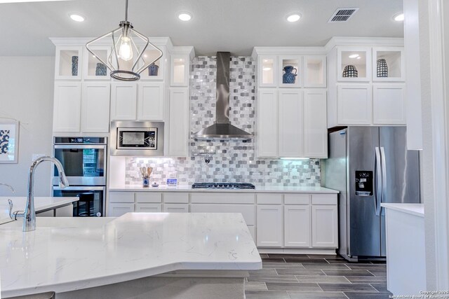 29519 Elkhorn, Fair Oaks Ranch, TX 78015 - kitchen with stainless steel appliances, wall chimney exhaust hood, white cabinetry, glass insert cabinets, and backsplash