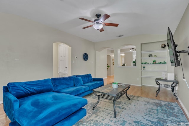 9427 Hacienda Acres, San Antonio, TX 78245 - living room featuring arched walkways, ceiling fan, and wood finished floors