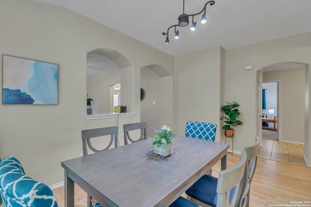 9427 Hacienda Acres, San Antonio, TX 78245 - dining space with arched walkways and light wood-style flooring