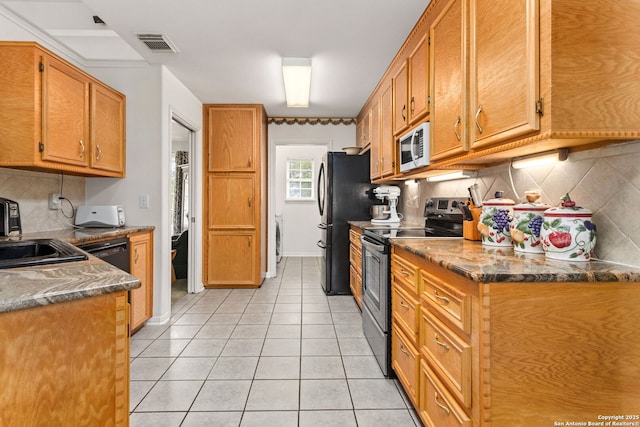 655 Shepherds, Bulverde, TX 78163 - kitchen featuring stainless steel appliances, tasteful backsplash, light tile patterned floors, washer / clothes dryer, and brown cabinets