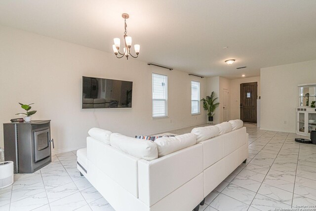 8298 Assumption Dr, San Antonio, TX 78254 - living room featuring light marble finish flooring, a chandelier, and a wood stove