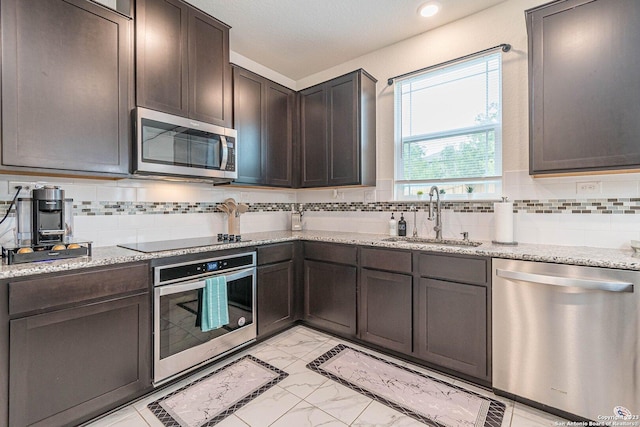 8298 Assumption Dr, San Antonio, TX 78254 - kitchen featuring appliances with stainless steel finishes, light marble finish flooring, dark brown cabinetry, backsplash, and recessed lighting